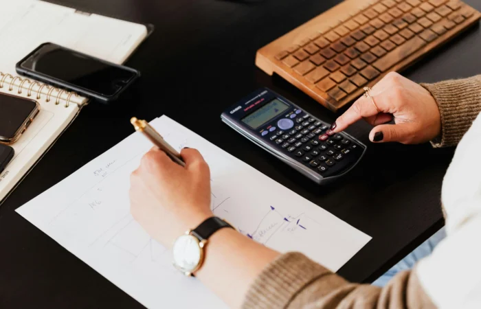 Księgowa wykonująca obliczenia na kalkulatorze i zapisująca dane w biurze rachunkowym Sylwia Stelmasiewicz Księgowa wykonująca obliczenia na kalkulatorze i zapisująca dane w biurze rachunkowym Sylwia Stelmasiewicz